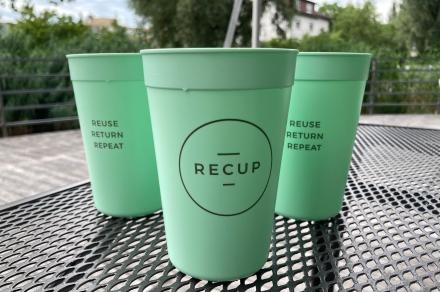 Türkisfarbene Recup Becher stehen auf einem Gartentisch