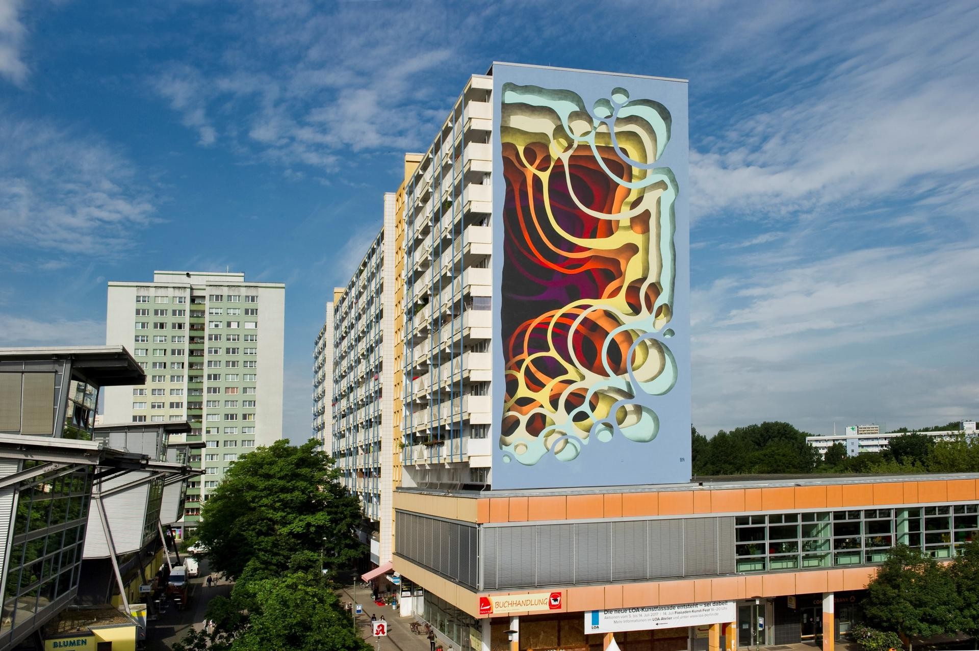 Ein mehrstöckiges Wohnhaus mit einem großflächigen Mural von 1010