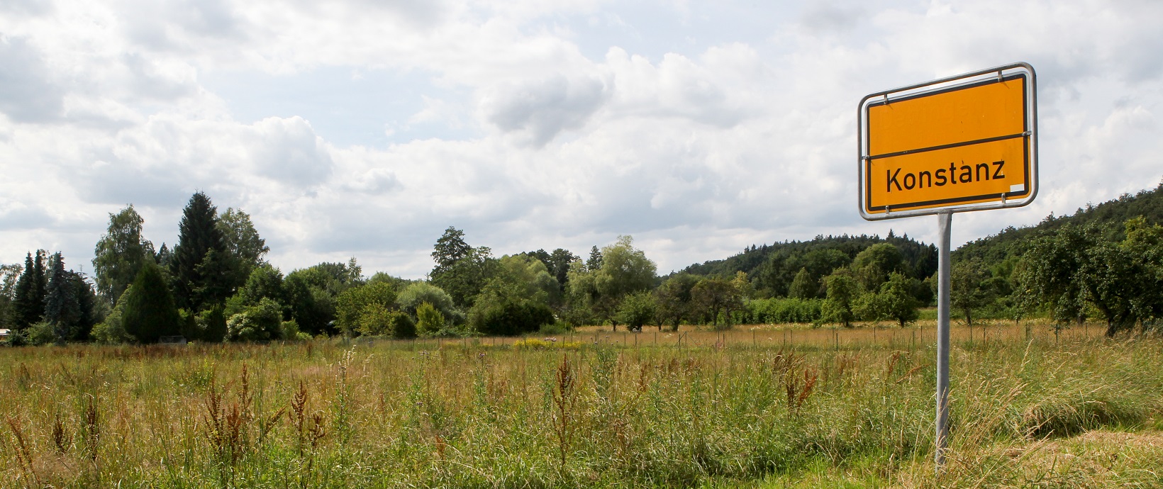 Fotos eines Stadtschildes vor dem Grün des heutigen Hafners