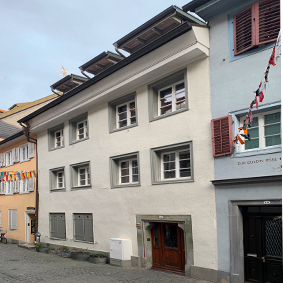 Bild Konradigasse von der Straße aus, gelbes, weißes, blaues Haus