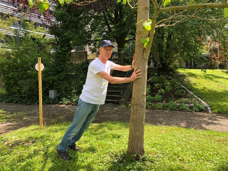 Übungsleiter Herbert Buffen stützt sich mit beiden Händen gegen einen Baum.