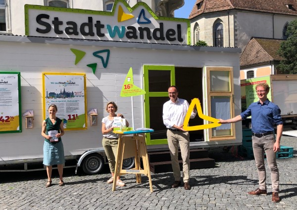 Städtische Mitarbeitende stehen mit dem Oberbürgermeister vor dem Stadtwandel-Mobil