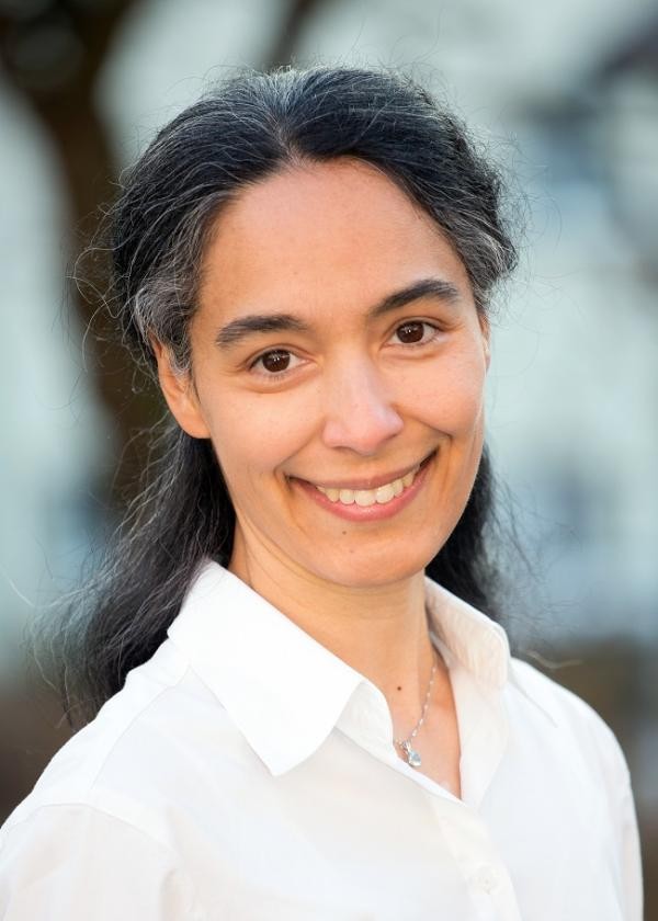 Portrait einer  Frau in weißer Bluse und langem, angegrauten Haar.