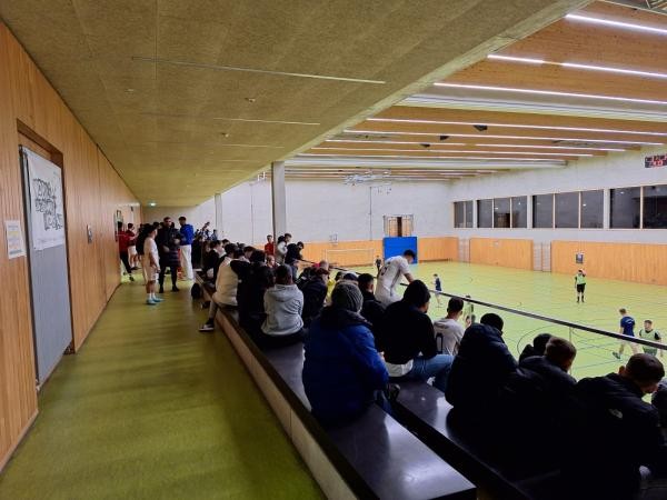 Blick entlang der vollen Zuschauerränge in der Halle, man sieht ein Stück vom Spielfeld, auf dem gerade gespielt wird.