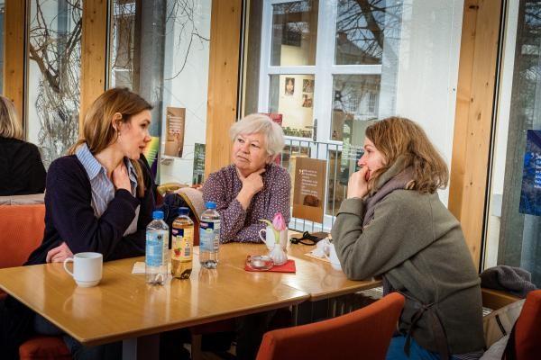 Drei Personen sitzen um einen Tisch