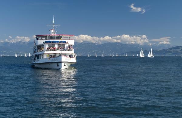 Ein weißes Schiff mit Segelbooten im Hintergrund