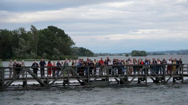 Viele Menschen auf einem Holzsteg über dem Wasser