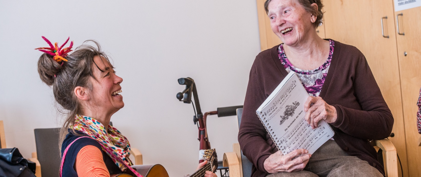 Zwei Frauen beim Singen und Gitarre spielen